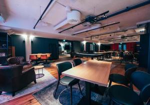 a room with tables and chairs and a pool table at Hotel Mestari in Helsinki