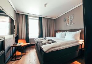 a hotel room with a bed and a television at Clarion Hotel Mestari in Helsinki