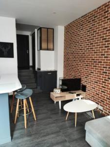 - un salon avec un canapé et un mur en briques dans l'établissement Le Havre, 1 chambre , appartement Sympa en centre ville, au Havre
