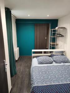 - une chambre avec 2 lits et un mur bleu dans l'établissement Le Havre, 1 chambre , appartement Sympa en centre ville, au Havre