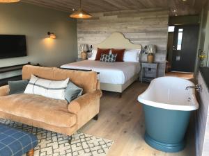 a bedroom with a bed and a couch and a tub at Uig Sands Rooms in Uig
