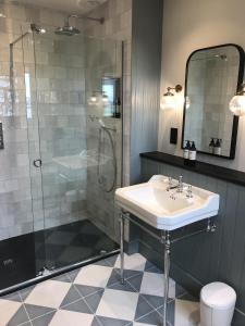 La salle de bains est pourvue d'un lavabo et d'une douche. dans l'établissement Uig Sands Rooms, à Uig