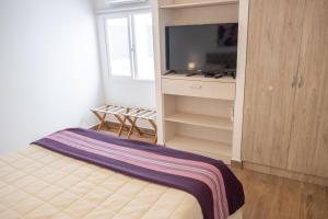 a bedroom with a bed and a flat screen tv at Augusta Deluxe in Salta