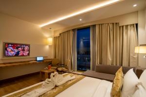 バラナシにあるCelebrant Hotelのベッドと大きな窓があるホテルの部屋