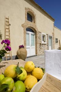 einen Haufen Zitronen auf einem Tisch vor einem Haus in der Unterkunft Hotel Borgo Pantano in Syrakus