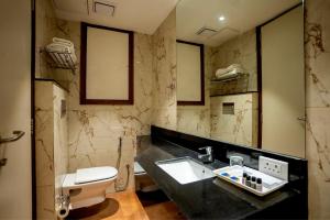 a bathroom with a sink and a toilet at Celebrant Hotel in Varanasi