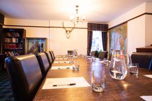 a conference room with a long wooden table and chairs at Dalmunzie Castle Hotel in Glenshee