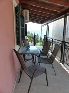 a patio with a table and chairs on a balcony at The Writers House in Ano Pavliana in Áno Pavliána