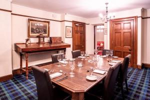 a dining room table and chairs in a room at Dalmunzie Castle Hotel in Glenshee