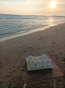 - un plateau de tasses sur une table sur la plage dans l'établissement Oasi del mare, à Granelli