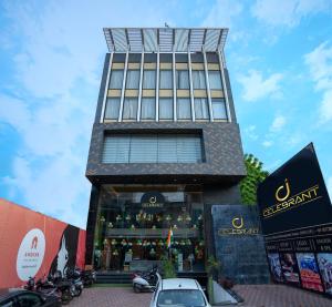 a tall building with a car parked in front of it at Celebrant Hotel in Varanasi