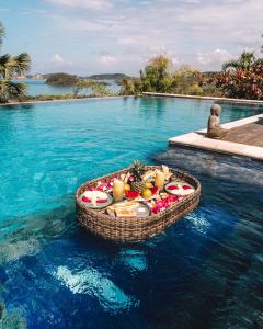 a basket of fruit in the water next to a swimming pool at The Endless Summer Resort in Bumbang
