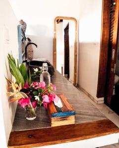 a table with a vase of flowers and books at The Endless Summer Resort in Bumbang