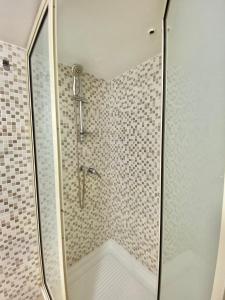 a bathroom with a shower with a glass door at Pamela House in Noto