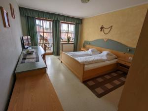 1 dormitorio con cama y escritorio. en Cafe-Bäckerei-Pension Weigl en Oberviechtach