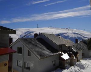 a snow covered hill with houses and a mountain at Hotham 3 Bedroom Apt - 24 Lawlers in Mount Hotham