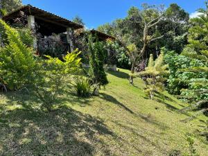 un jardin avec une maison et quelques buissons et arbres dans l'établissement Chalé romântico , rústico e vista de tirar o fôlego, à Guaramiranga