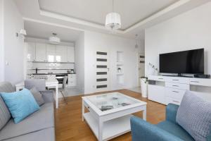 a white living room with a couch and a table at ECRU Spacious Premium Apartment with City View in Warsaw WWA4 in Warsaw