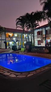 een groot blauw zwembad voor een gebouw bij CONDOMINIO COLONIAL APARTAMENTOS 150M DA PRAIA in Bombinhas