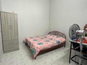 a bedroom with a bed and a fan at HomestayMuslim Di Teluk Intan in Teluk Intan