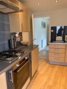 uma cozinha com um fogão e uma bancada em Modern 3 bed house in the heart of Morpeth town. em Morpeth