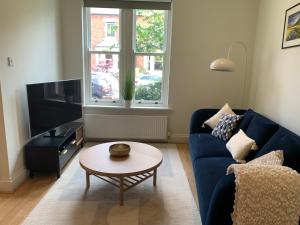 a living room with a blue couch and a table at Modern 3 bed house in the heart of Morpeth town. in Morpeth