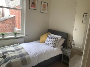 a bed in a small room with a window at Modern 3 bed house in the heart of Morpeth town. in Morpeth