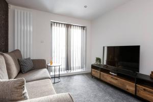 uma sala de estar com um sofá e uma televisão de ecrã plano em Victoria Apt - 2 bedroom Parking Wi-Fi Workers em Hyde