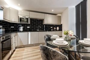 a kitchen with a glass table and chairs in a kitchen at Victoria Apt - 2 bedroom Parking Wi-Fi Workers in Hyde