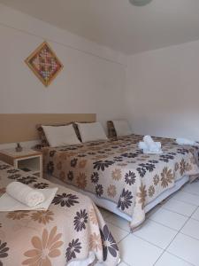 two beds sitting next to each other in a room at Pousada Paraíso Francês in Praia do Frances