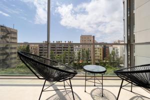 two chairs and a table in front of a window at ChicStays Apartment Vila Olímpica in Barcelona
