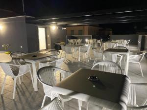 a restaurant with white chairs and tables and a laptop at IL VIAGGIATORE RELAIS SUL MARE in Gaeta
