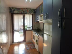 a kitchen with a refrigerator and a sink and a dishwasher at Centrico apartamento en Noja con acceso a Spa in Noja