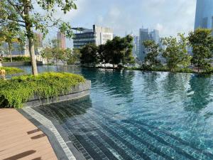 une grande piscine d'eau dans une ville avec des bâtiments dans l'établissement Infini Suites@ Continew Residence KL, à Kuala Lumpur