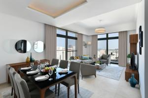 a dining room and living room with a table and chairs at Le Mirage Downtown in Doha