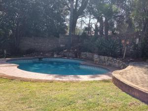 een zwembad in een tuin met een stenen muur bij The Jewel in Florida