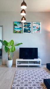 a living room with a television and a potted plant at Kids Love It! Fantastic Seaview with Infinite Pool, 5min to jetty, Food Spot-MangoHouse2 in Kota Kinabalu