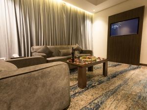 a living room with a couch and a tv at White Diamond Hotel Sari in Jeddah