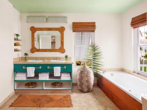 a bathroom with a tub and a sink and a mirror at Cambridge Beaches Resort and Spa in Somerset