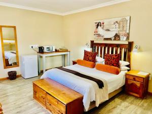 a bedroom with a large bed with orange pillows at Travalia Guest Farm in Nelspoort