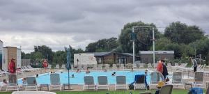 a large swimming pool with chairs and people in it at Tattershall lakes breaks Swan view in Tattershall