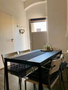 a dining room with a black table and chairs at Benvenuto Apartman in Budapest