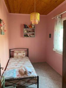 ein Schlafzimmer mit einem Bett in einer rosa Wand in der Unterkunft Our Country House in Vergia