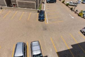 Milimani Cosy Condo في ناكورو: اطلالة علوية لسيارتين متوقفة في موقف للسيارات