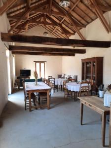 comedor con mesas y sillas y techos de madera en La métairie du château le Vignau, en Le Vignau