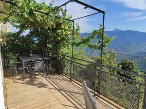 een balkon met een tafel en uitzicht op de bergen bij Maison de village avec vue sur les montagnes in Bigorno