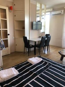 a room with a table and chairs and a television at Cozy apartment with balcony in Tbilisi City