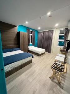 a bedroom with two beds and a blue wall at ChaoChaoINN in Chaozhou