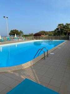une grande piscine d'eau bleue dans l'établissement Studio Marymer, à Cervione