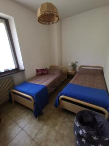 レードロにあるCasa Elisabettaのベッドルーム1室(青いシーツが備わるベッド2台付)